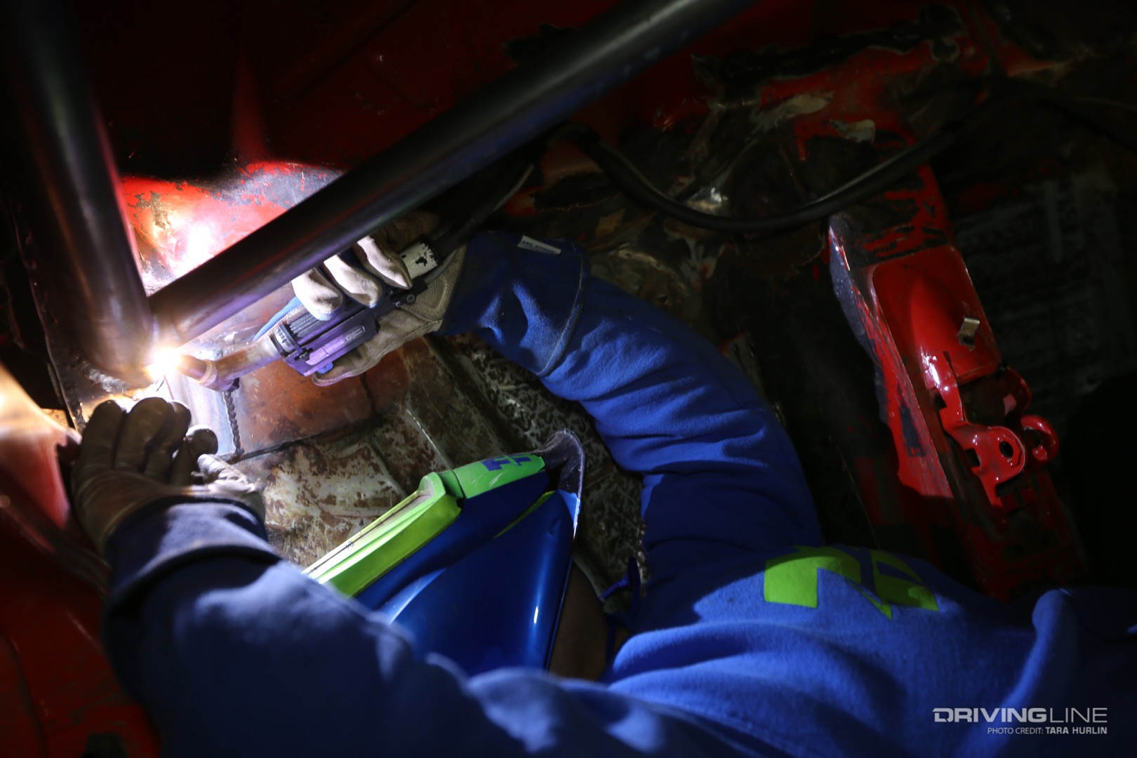 Ryan of Thompson Racing Fabrication twisting in odd positions to weld a roll cage.