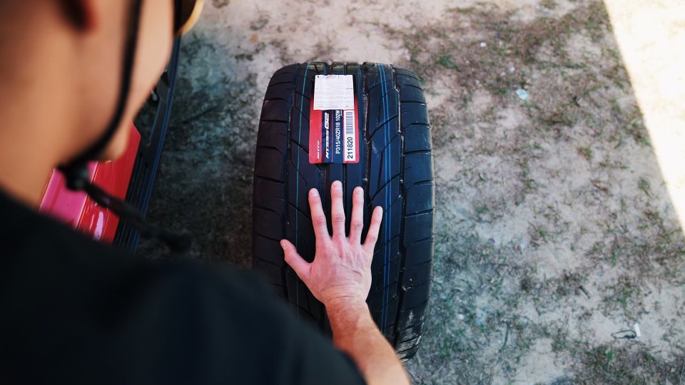 AdamLZ rolls one of his Blitz wheels wrapped in Nitto NT555G2 tires to be mounted on his Nissan S15 competition drift car