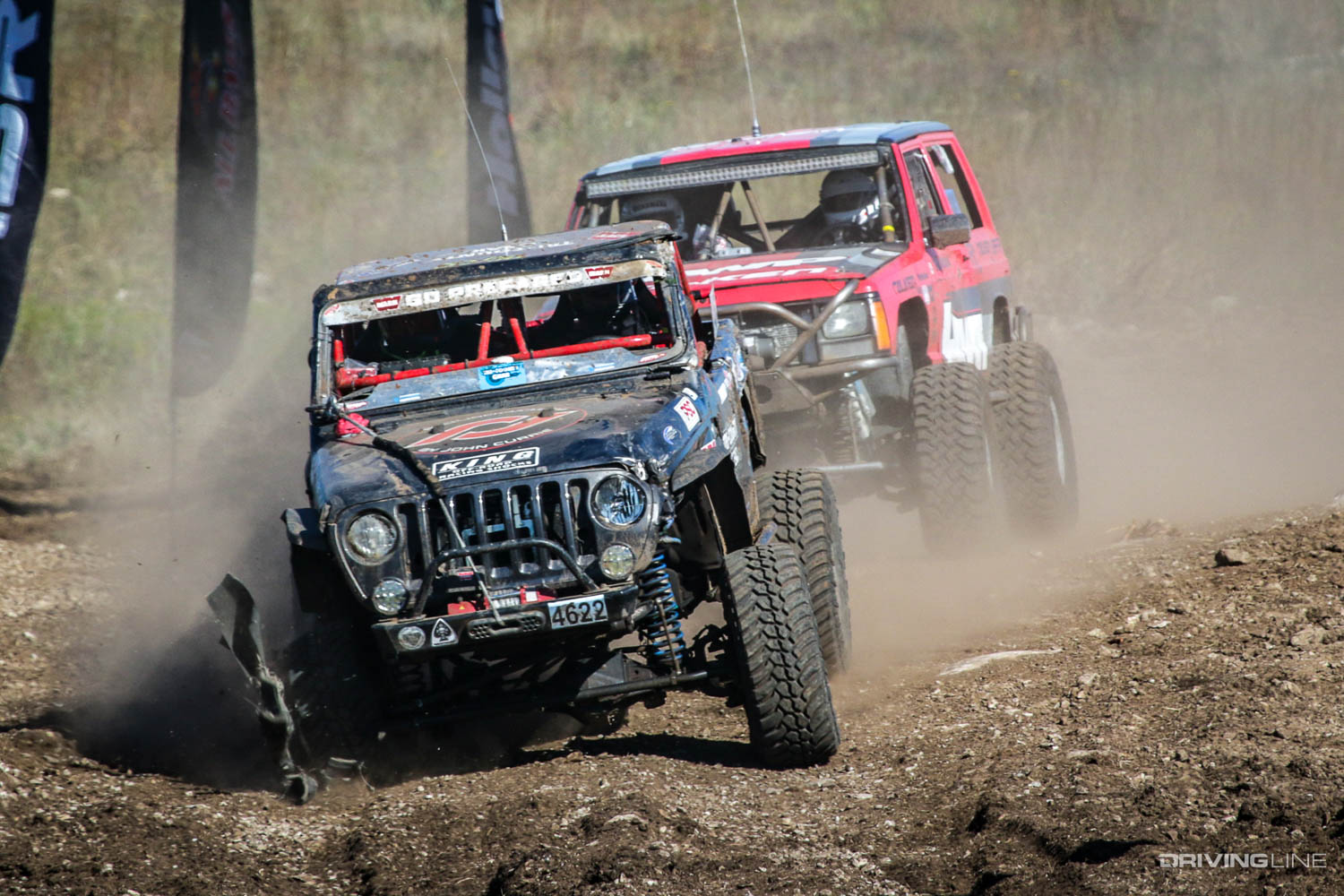 Two stock Jeeps driving around a corner
