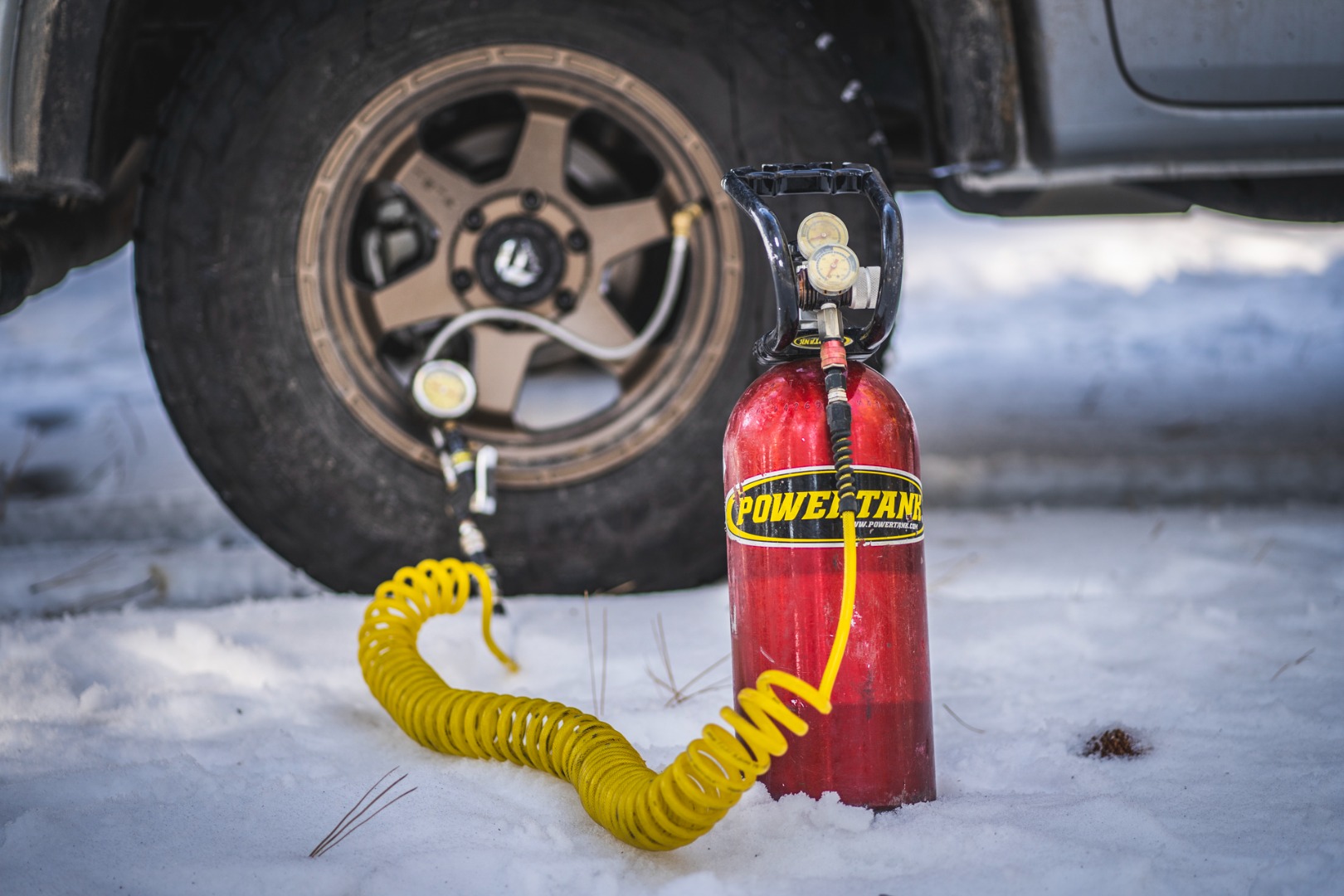 Powertank 10lbs Co2 bottle in front of a tire