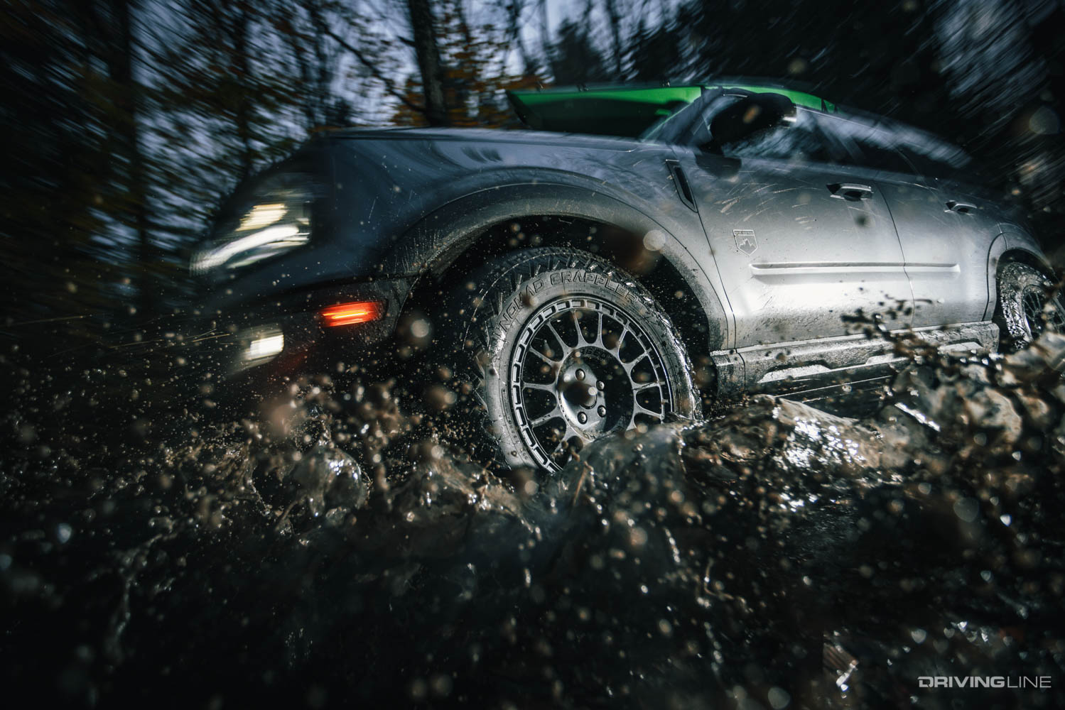 Nitto Nomad Grappler all-terrain crossover tire driving through muddy water