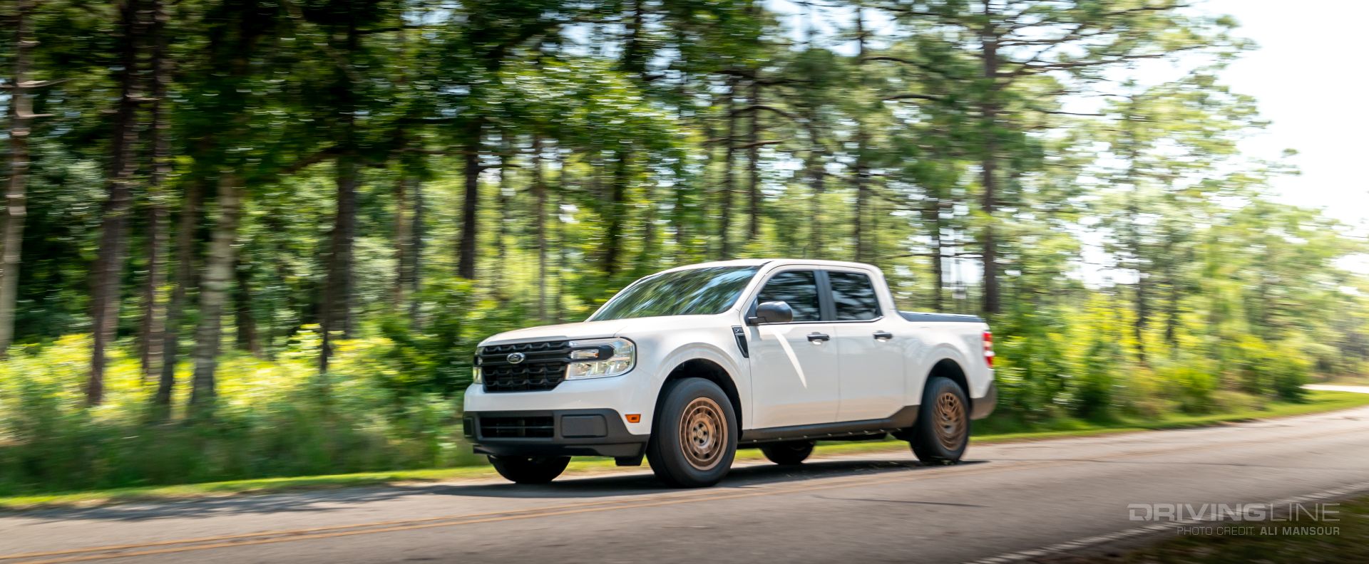 2022 Ford Maverick Hybrid driving on road in trees