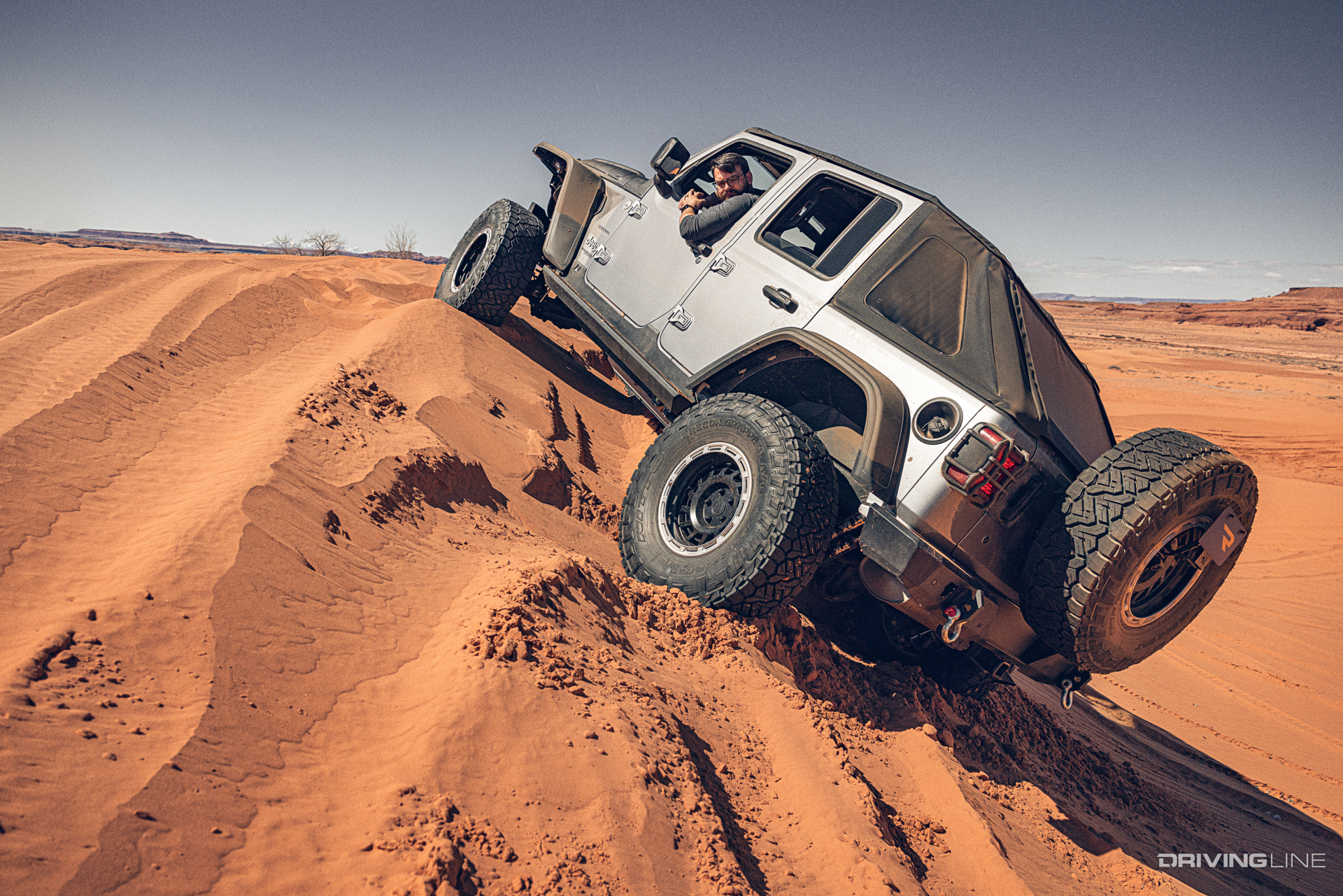 Nitto Recon Grappler equipped jeep wrangler driving up a sand dune