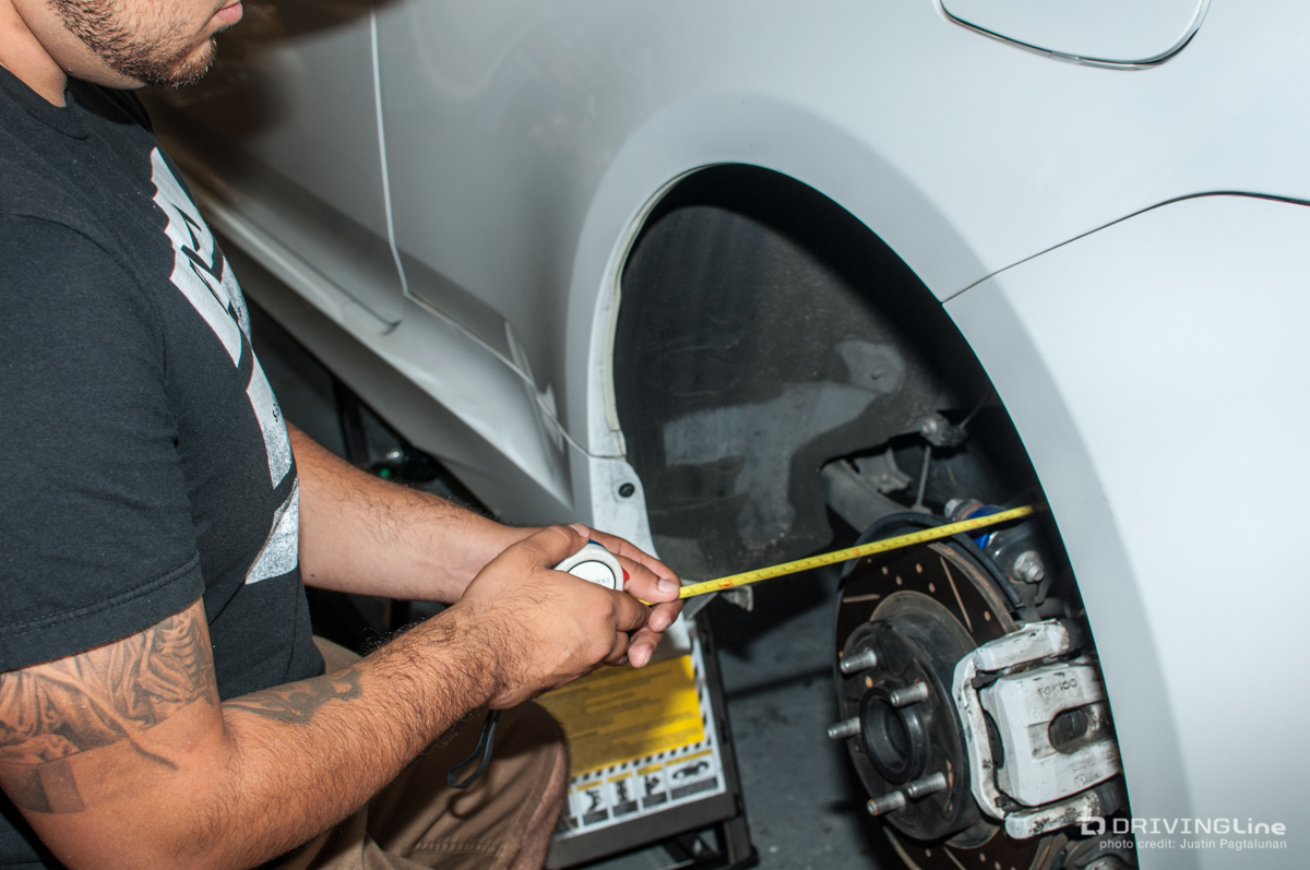 Man measuring width of a wheel well