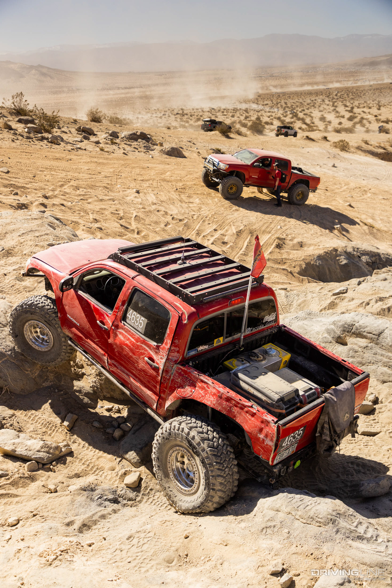 Two red Toyota Tacoma trucks off-road in johnson valley, CA